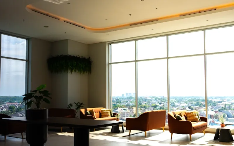 Double-height living room with tall windows flooding the duplex with natural light