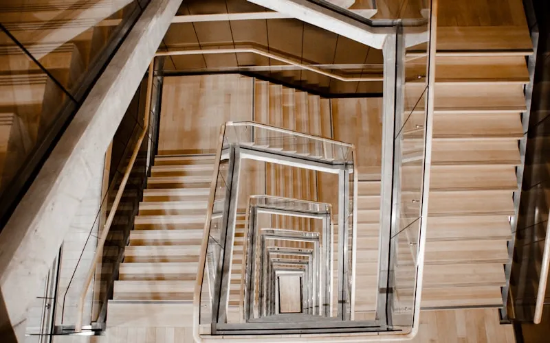 Modern duplex staircase with glass railing and wooden steps as design feature