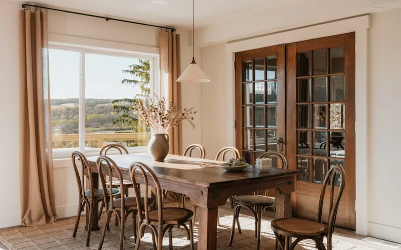 French country dining room with rustic wooden table and fresh flowers