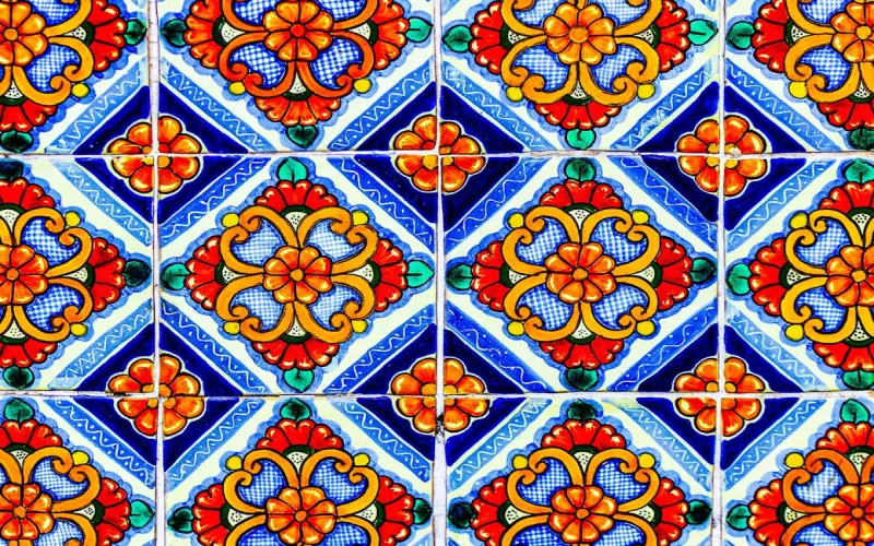 Mexican handcrafted materials including Talavera tiles, carved wood furniture, and blown glass