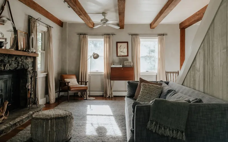 Modern rustic living room combining exposed stone fireplace with contemporary furniture