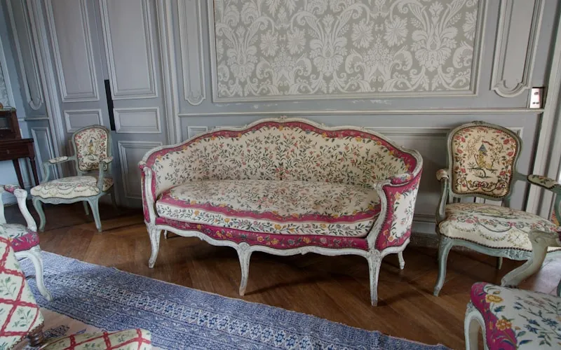Ornate Victorian furniture featuring carved wood details and rich upholstery